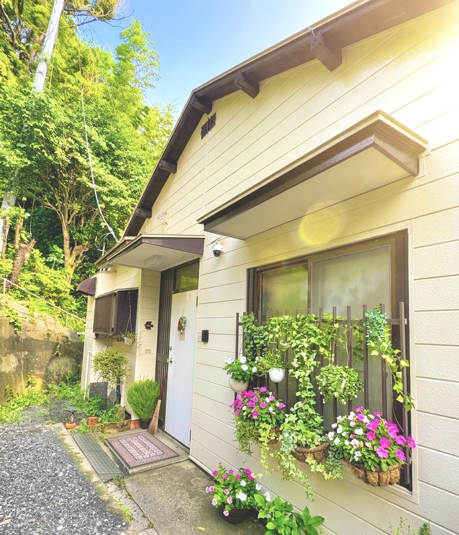 花に囲まれた、白い平屋のぽの